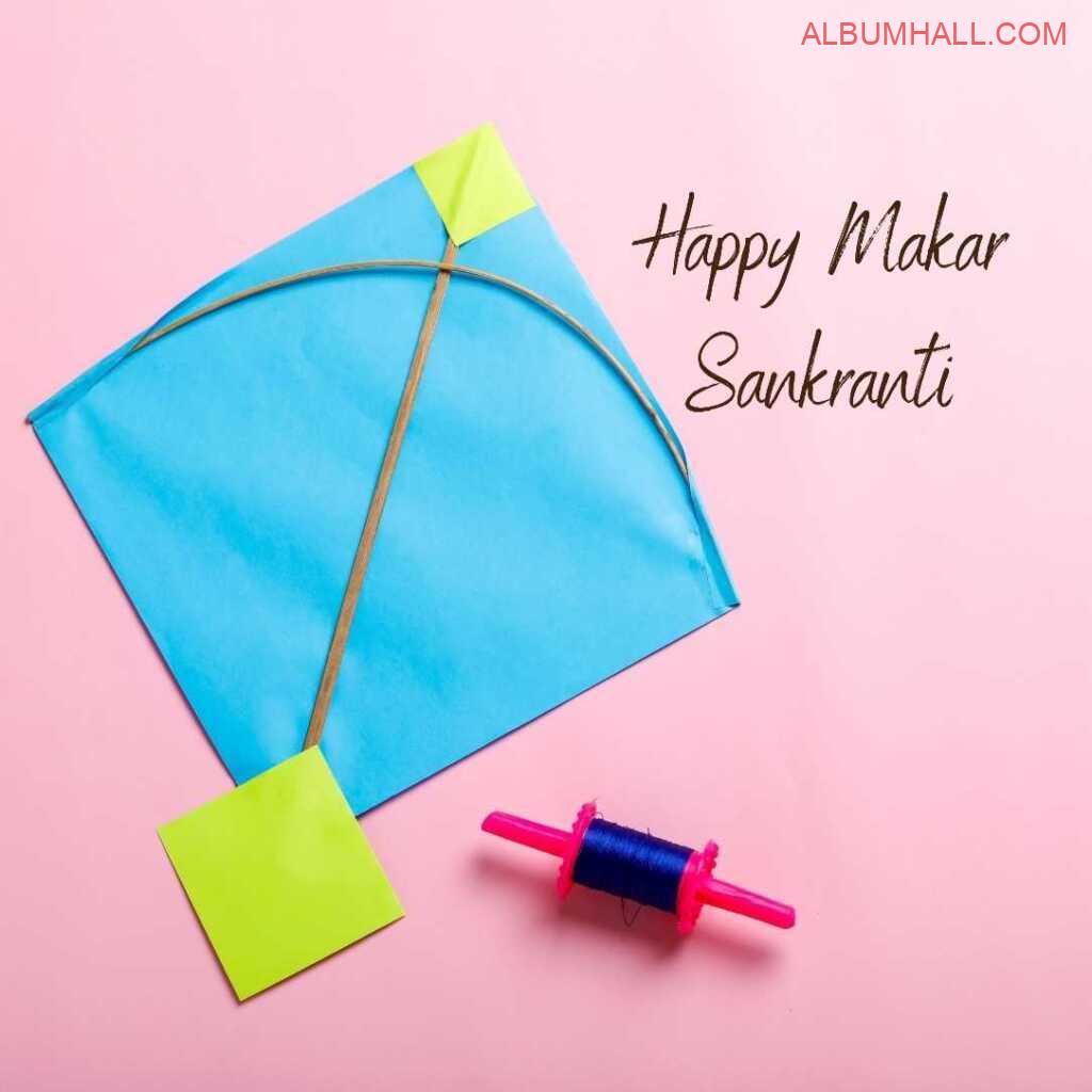 Sankrant blue yellow kite & thread lying on a pink color table