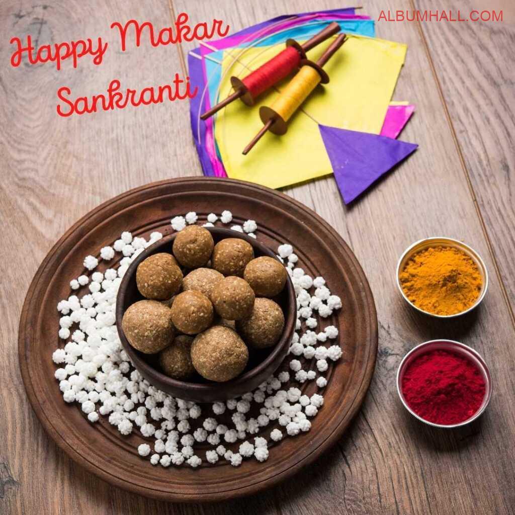 Dark brown plate and bowl with sweets, yellow and red color alongwith kites on Sankrant time
