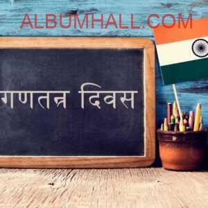 Republic day wishes in Hindi written on a slate with pen stand and small Indian flag