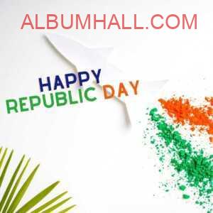 green, saffron colors used to draw Indian flag on white table to wish republic day with green palm leaves