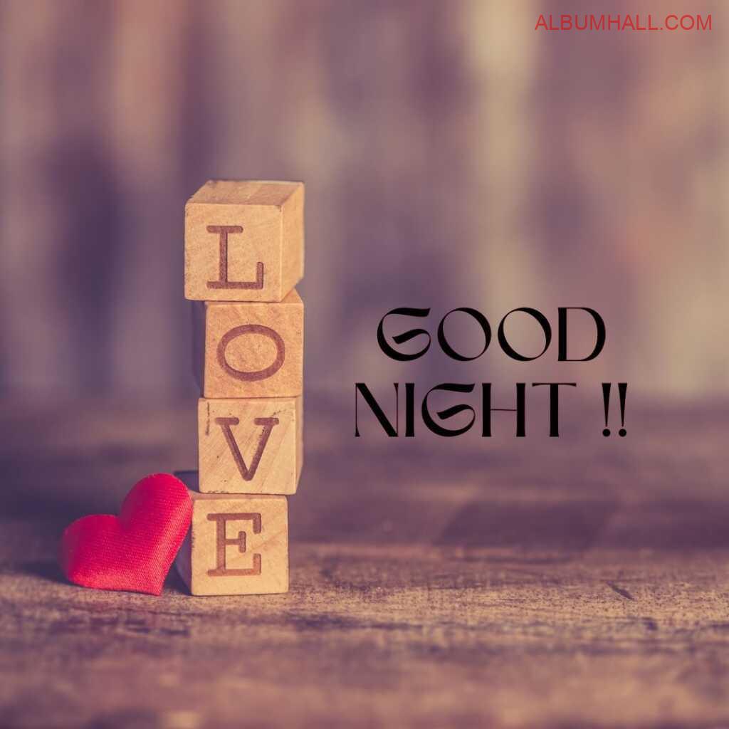 LOVE word mentioned on brown color blocks with little red heart lying on table to wish good night to the loved ones
