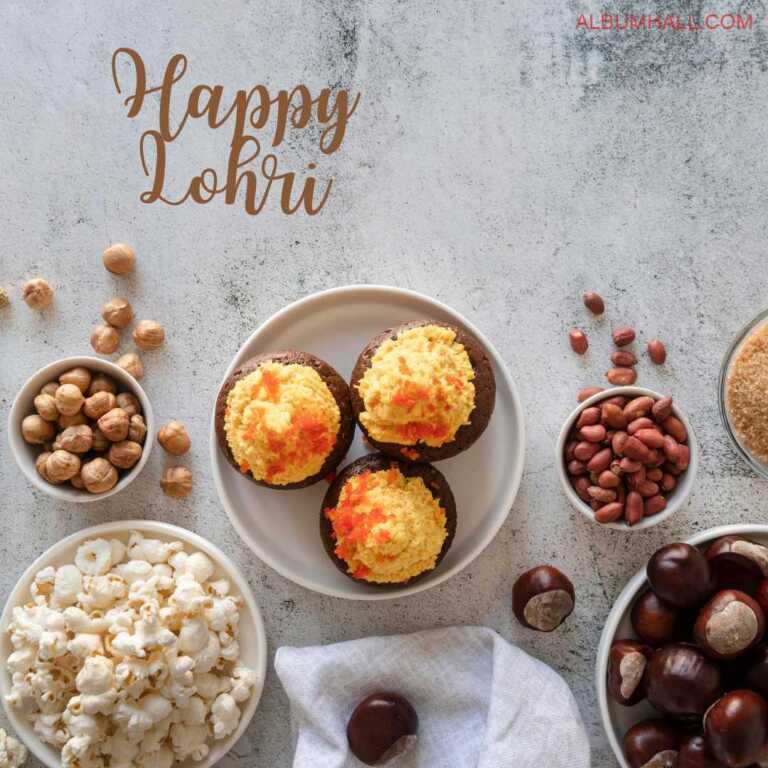 Happy Lohri note written on white paper with chickpea, peanuts, dates popcorn and three butterscotch & chocolate cupcakes on the table in separate bowls