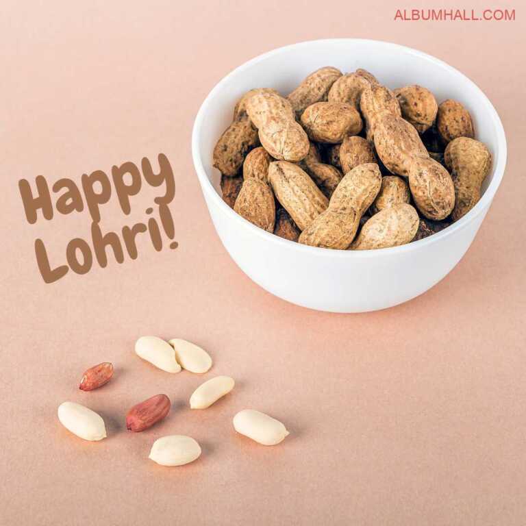 White bowl filled with raw peanuts and few of them lying on the pink color table for Lohri festival