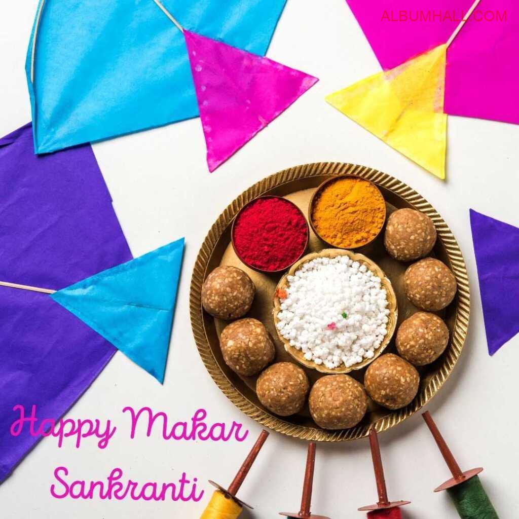 Sankrant special sweets in plate and three kites on table