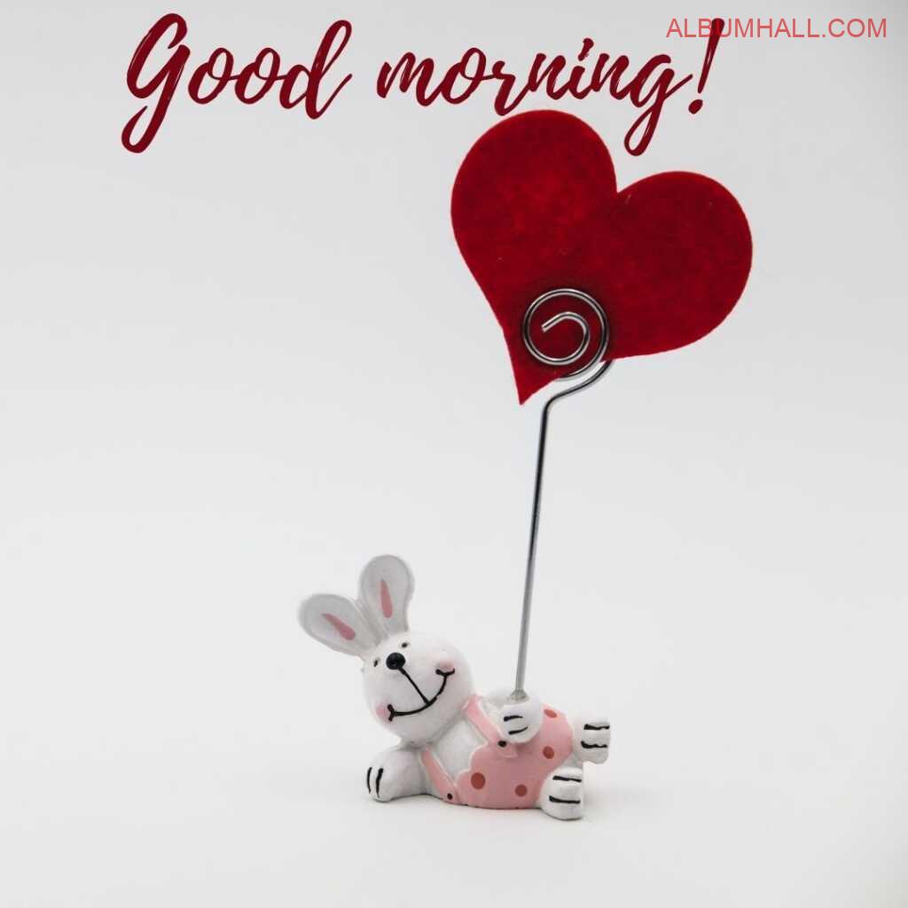 a rabbit holding a red heart decorative item reflecting good morning mentioned around heart