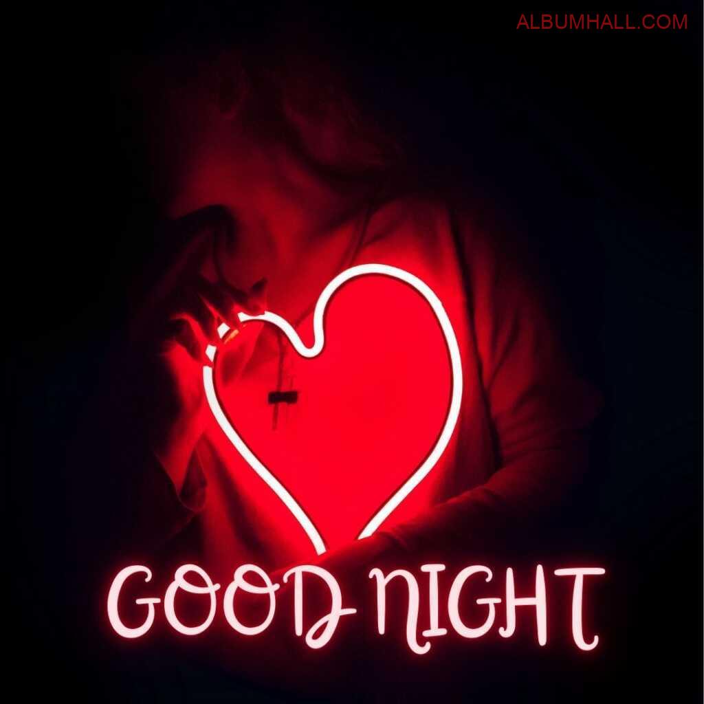 Boy holding red heart shaped glowing light saying good night