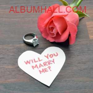 Pink rose and diamond ring with "will you marry me?" note on table for wishing happy propose day