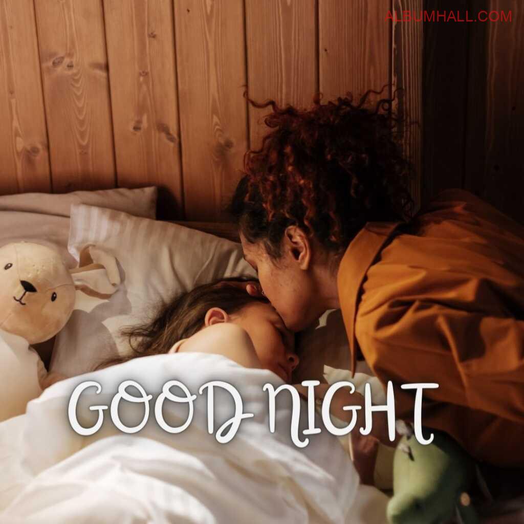 Small girl sleeping with her brown teddy on her bed and her mom giving her a good night kiss