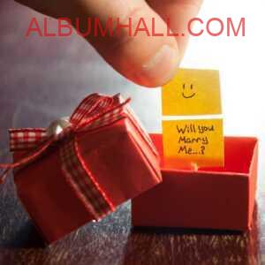 Gift box with "will you marry me?" note on yellow paper and smiley on propose day