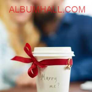 White Coffee cup with red ribbon and ring saying "marry Me?" on propose day